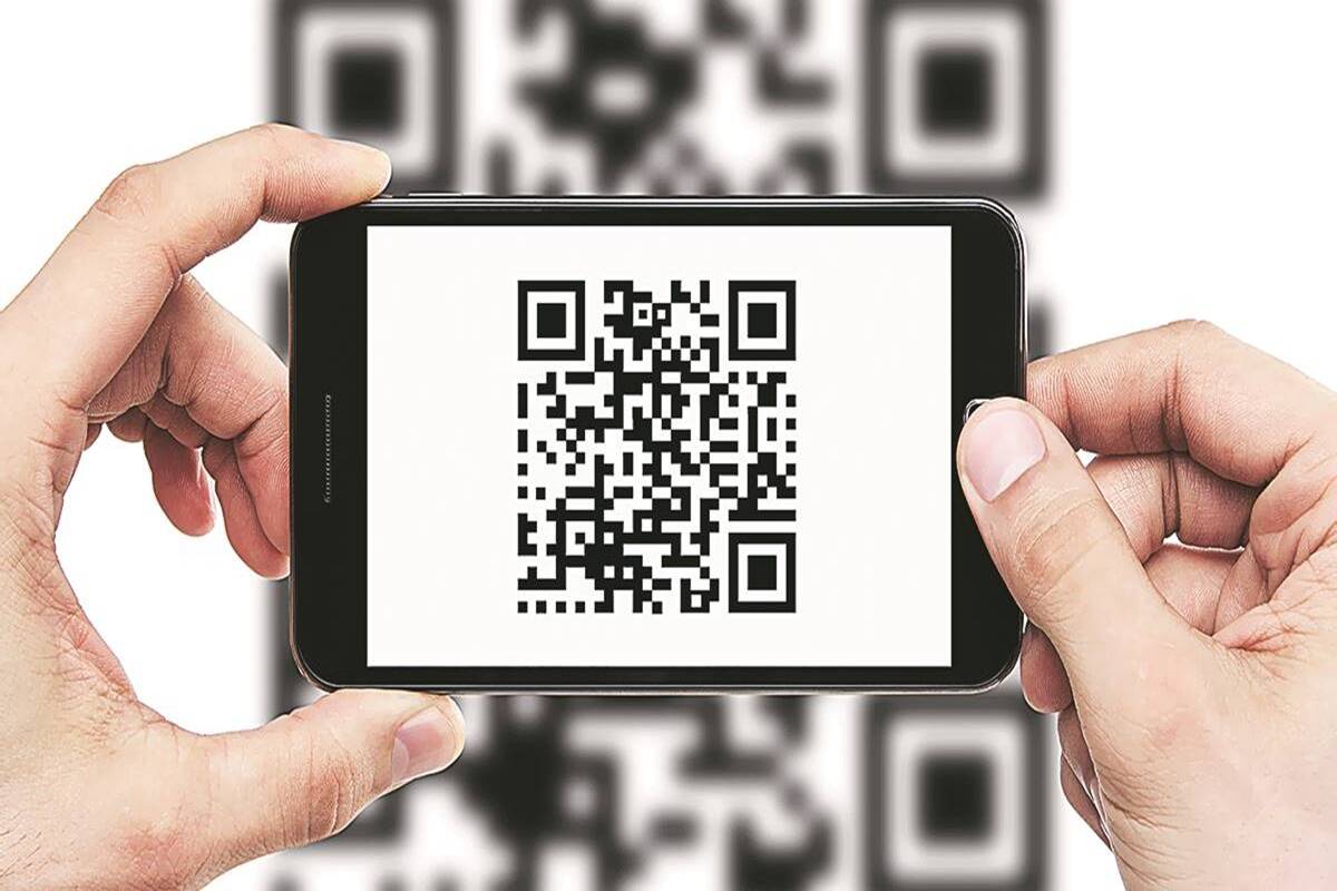 a hand scanning a QR code with an iPhone